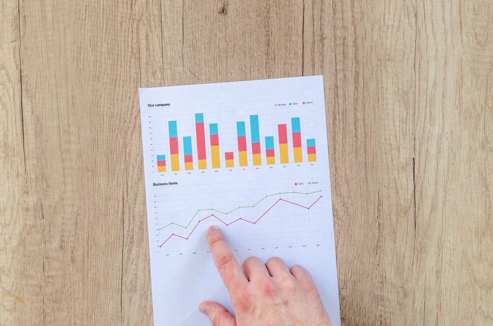 hand pointing in the paper with graph