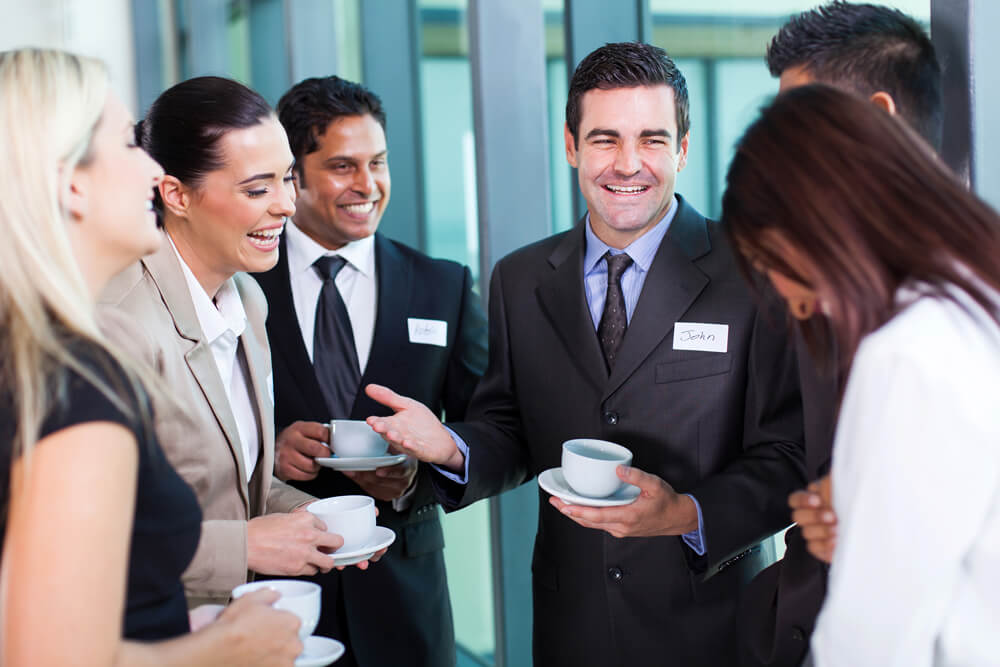 Colleagues laughing over cup of coffee