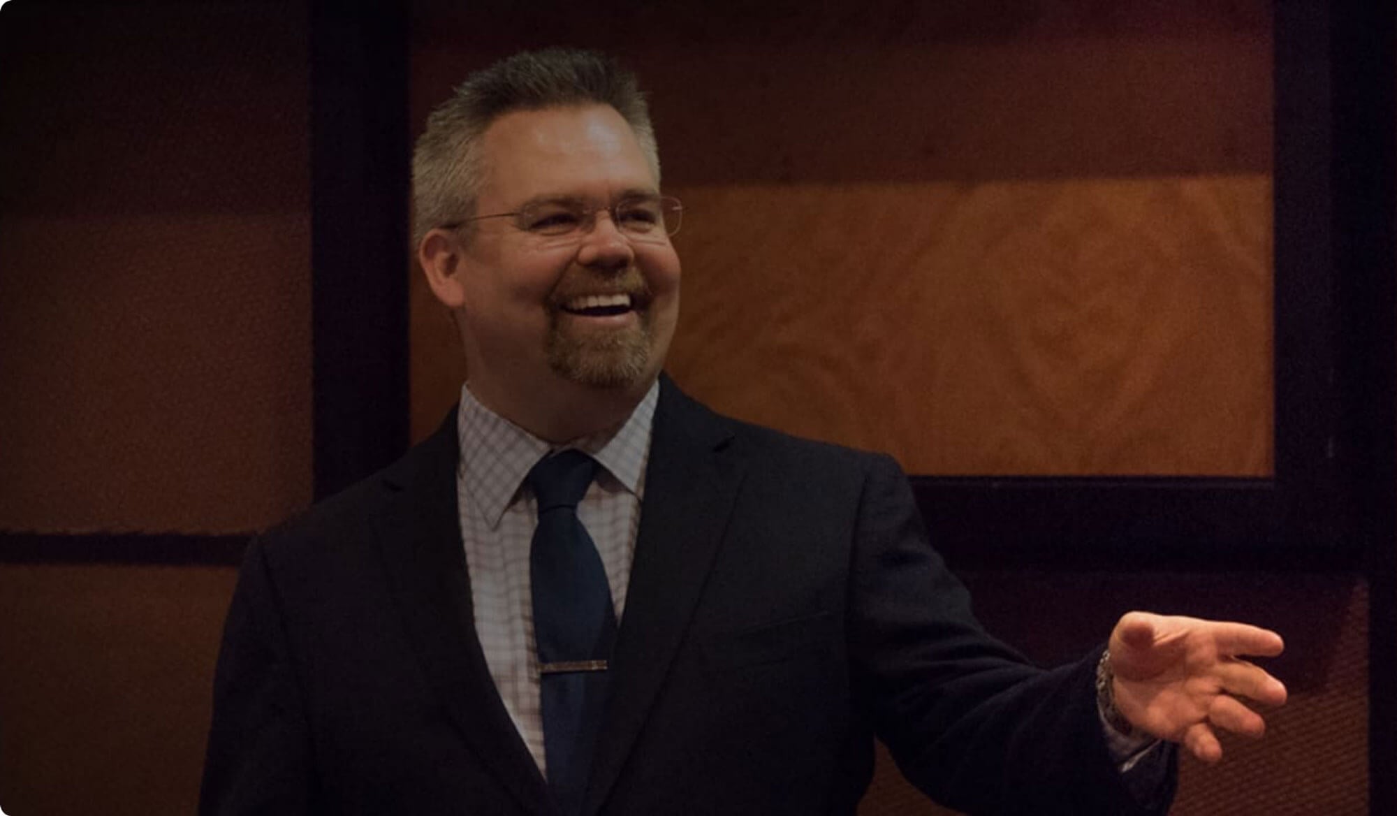 man in suit happily lecturing